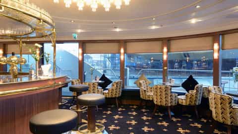 A bar lounge with seating and tables by the window - MS Jane Austen, Riviera Travel