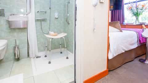 A cruise ship cabin bathroom with a shower seat - ms La Belle de Cadix, CroisiEurope