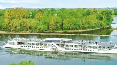 A riverboat cruises on a wide river with green banks - ms Loire Princesse, CroisiEurope
