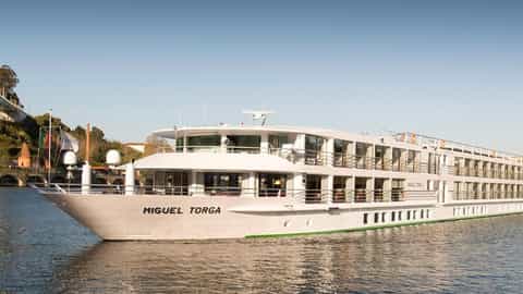 A white river cruise ship sails on a blue river - MS Miguel Torga, CroisiEurope