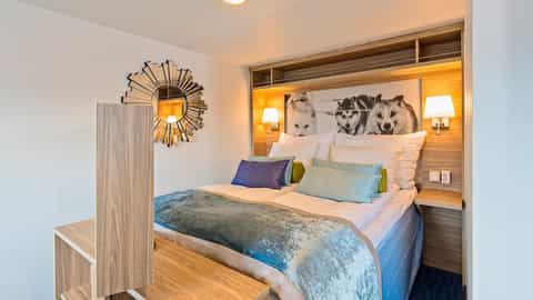 A cabin bed with husky dog art above the pillows - MS Nordkapp, Hurtigruten