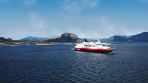 A cruise ship sails on a calm blue sea near islands - MS Nordlys, Hurtigruten