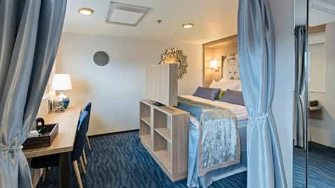 A cruise ship cabin with a bed and a desk - MS Nordnorge, Hurtigruten