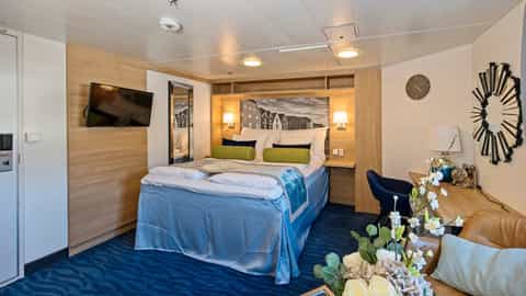 A cruise ship cabin with a bed and seating area - MS Polarlys, Hurtigruten
