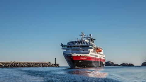A ship sails on the water under a clear blue sky - MS Polarlys, Hurtigruten