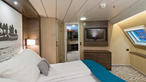 A modern cruise ship suite bedroom with a bed and TV - MS Richard With, Hurtigruten