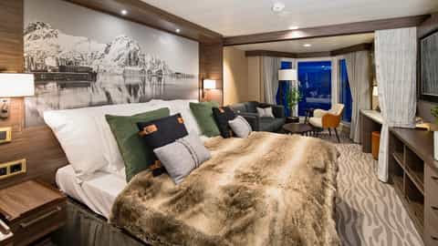 A suite bedroom with a sitting area and large window - MS Richard With, Hurtigruten