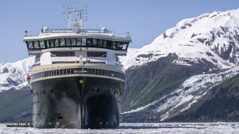 A ship sails through icy waters near a glacier - MS Roald Amundsen, HX Expeditions