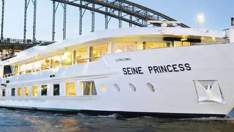 A white river cruise ship sails under a bridge - ms Seine Princess, CroisiEurope