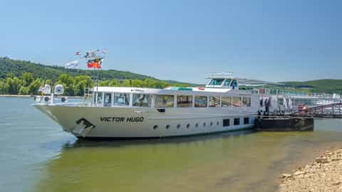 A white river cruise ship is docked on a sunny day - ms Victor Hugo, CroisiEurope