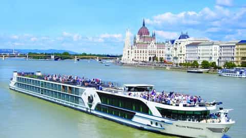 A river cruise ship sails past the Hungarian Parliament Building - MS William Wordsworth, Riviera Travel