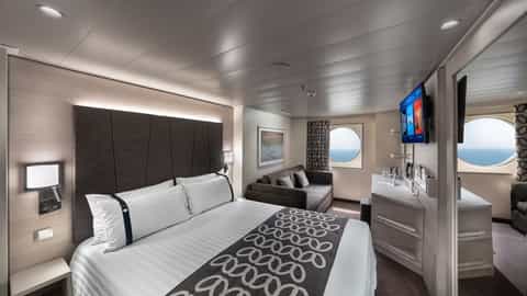 A cruise ship suite with a bed, sofa, and ocean view - MSC Euribia, MSC Cruises