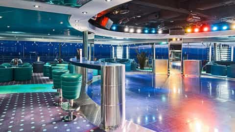 A modern bar lounge with a dance floor and seating - MSC Lirica, MSC Cruises