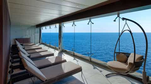 Sun loungers and a hanging chair face the ocean - MSC Magnifica, MSC Cruises