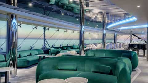 A modern lounge with green velvet seating and a piano - MSC Poesia, MSC Cruises