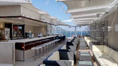 An outdoor bar lounge with seating and ocean views - MSC Seashore, MSC Cruises