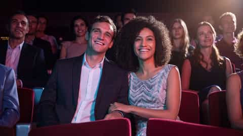 A couple smiles while watching a show in a theater - MSC Seaside, MSC Cruises