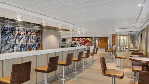 A modern bar with stools and tables - National Geographic Gemini, Lindblad Expeditions