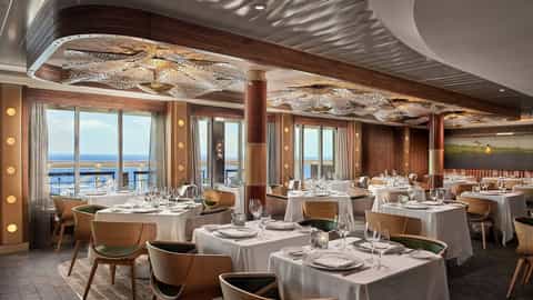 A formal dining room with tables set for dinner - Norwegian Bliss, Norwegian Cruise Line