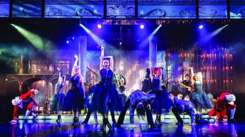 Performers in costumes dance on a stage with theatrical lighting - Norwegian Breakaway, Norwegian Cruise Line