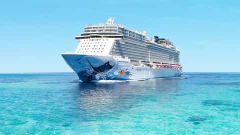 A large cruise ship sails on a clear blue ocean - Norwegian Escape, Norwegian Cruise Line