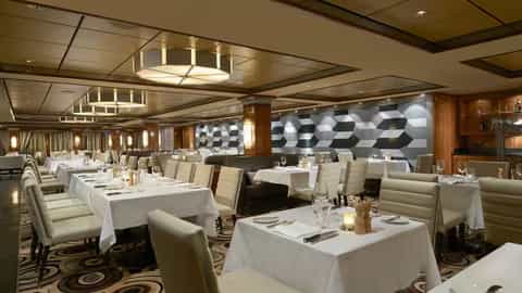 A formal dining room with many set tables - Norwegian Gem, Norwegian Cruise Line