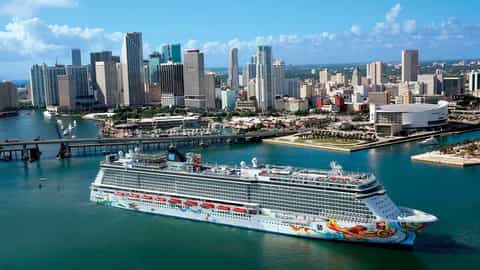 A large cruise ship sails past a city skyline - Norwegian Getaway, Norwegian Cruise Line