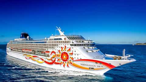 A large cruise ship sails on a bright blue sea - Norwegian Sun, Norwegian Cruise Line