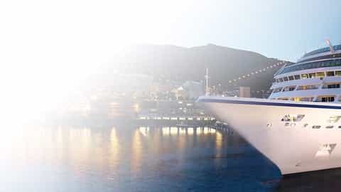 A cruise ship is docked in a port city at dusk - Oceania Sirena, Oceania Cruises