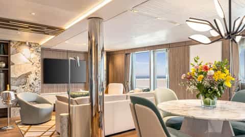 A suite living and dining area with a view of the sea - Oceania Vista, Oceania Cruises