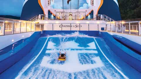 A person surfs on a flowrider wave machine - Ovation Of The Seas, Royal Caribbean