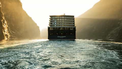 A cruise ship travels through a narrow fjord - Queen Elizabeth, Cunard