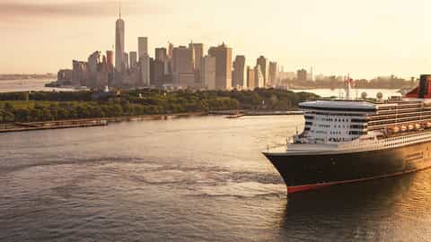 A large cruise ship sails past the New York City skyline - Queen Mary 2, Cunard