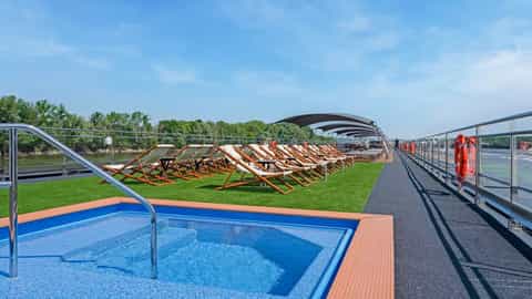 A pool deck with lounge chairs and a small pool - Riviera Radiance, Riviera Travel