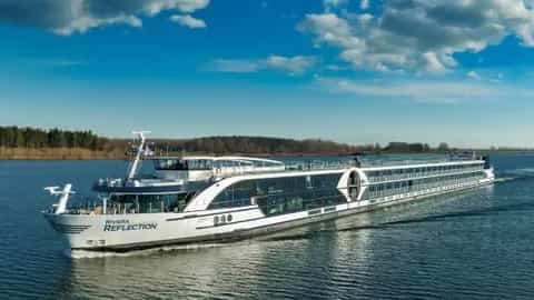 A river ship sails on a blue waterway - Riviera Reflection, Riviera Travel