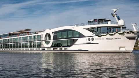 A white river cruise ship sails on the water - Riviera Rose, Riviera Travel