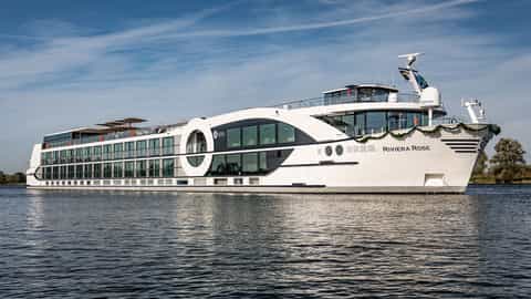 A white river cruise ship sails on the water - Riviera Rose, Riviera Travel