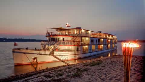 A large riverboat is docked at sunset - RV Jahan, Lindblad Expeditions