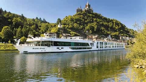 A river cruise ship sails past a castle on a hill - Scenic Jewel, Scenic Cruises