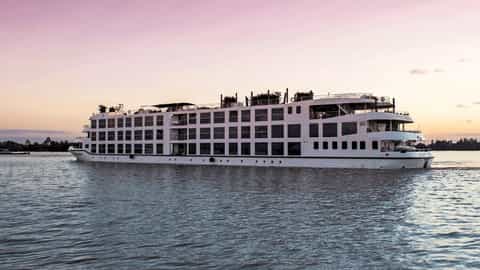 A river cruise ship sails on the water at sunset - Scenic Spirit, Scenic Cruises