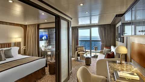 A suite with a bed, seating area, and ocean view - Seabourn Pursuit, Seabourn Cruises
