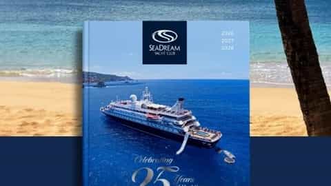 A yacht club brochure is displayed on a beach - SeaDream I, SeaDream Yacht Club