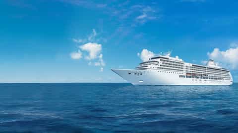 A large white cruise ship sails on a blue ocean - Seven Seas Mariner, Regent Seven Seas Cruises