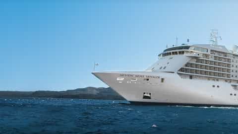 A large white cruise ship sails on the ocean - Seven Seas Voyager, Regent Seven Seas Cruises