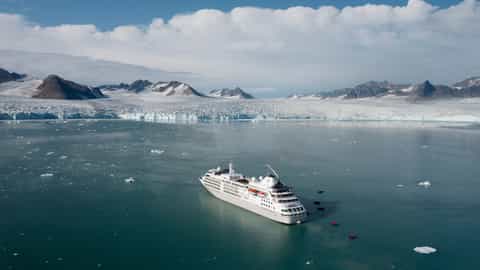 A cruise ship sails in arctic waters near a glacier - Silver Cloud, Silversea Cruises