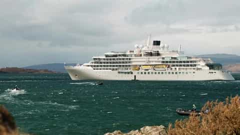 A large white ship sails on the water near land - Silver Endeavour, Silversea Cruises