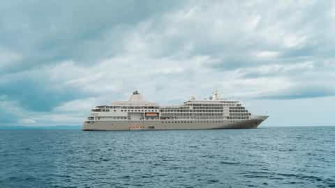A large cruise ship sails on the ocean under a cloudy sky - Silver Shadow, Silversea Cruises