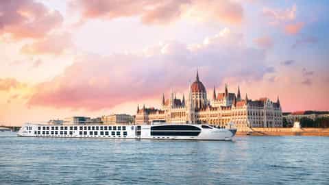 A river ship sails past Budapest's Parliament building - SS Maria Theresa, Uniworld