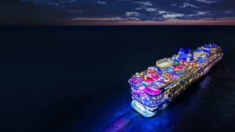 A large cruise ship is illuminated at sea at night - Star Of The Seas, Royal Caribbean