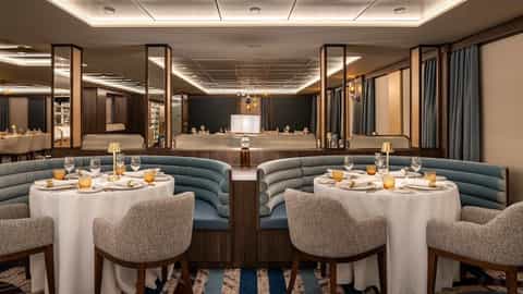 A formal dining room with set tables and booths - Star Seeker, Windstar Cruises
